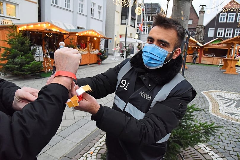 Nach dem Check ein rotes Bändchen um den Arm...
