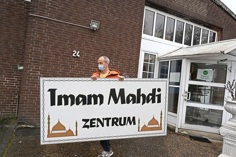 Ein Polizist transportiert das Schild ab, das sich über dem Haupteingang des Imam Mahdi Zentrums befand.