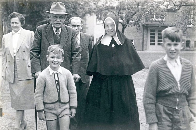 Die Ordensschwester im Kreis ihrer Familie im Garten in Marienthal: (hinten,von links) Maria Balthesen geb. van Hal (Nichte), Johann van Hal (Bruder), Richard Balthesen (Ehemann von Maria Balthesen) und Schwester Laudeberta, vorne Johannes und Alfons Balthesen (Großneffen), wahrscheinlich aufgenommen im Jahr 1954. Foto: LWL-Medienzentrum für Westfalen. Veröffentlichung mit dieser Pressemitteilung honorarfrei.