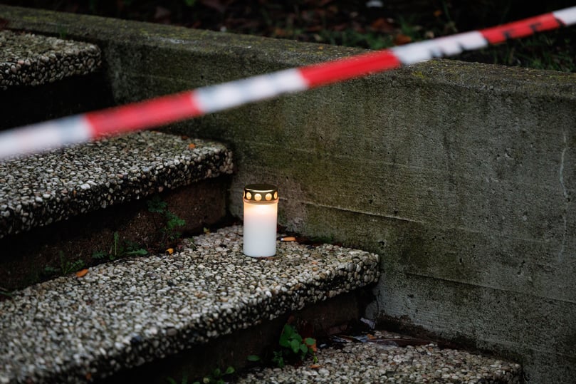 Eine Trauerkerze steht vor dem Eingang der Kaufmännischen Schulen Tecklenburger Land in Ibbenbüren: Ein 17-jähriger Schüler soll seine Lehrerin erstochen haben. Danach wählte er selbst den Notruf. Die Ermittlungen zu den Hintergründen der Tat laufen.