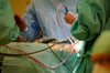 Blick in einen OP-Saal während einer Operation: Auch bei Material wie etwa OP-Mänteln soll genauer auf die Kosten geschaut werden.