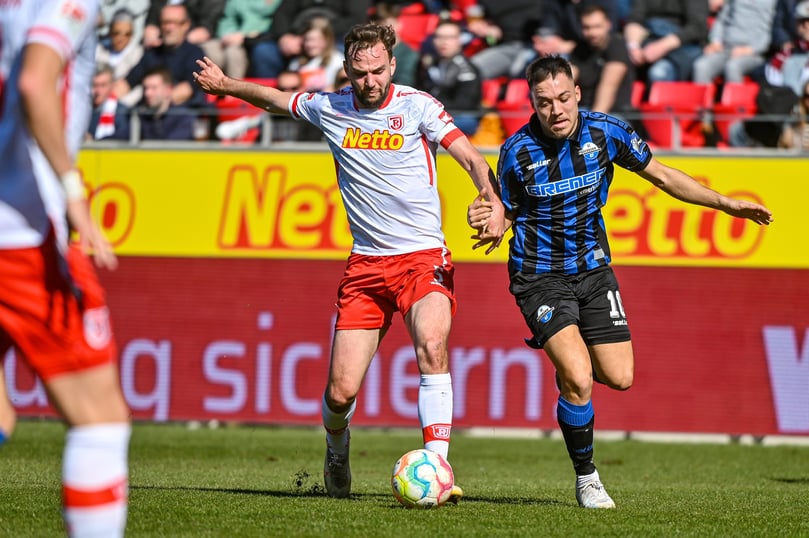 Benedikt Gimber von Regensburg (links) kämpft mit Julian Justvan von Paderborn um den Ball. Foto: Armin Weigel/dpa