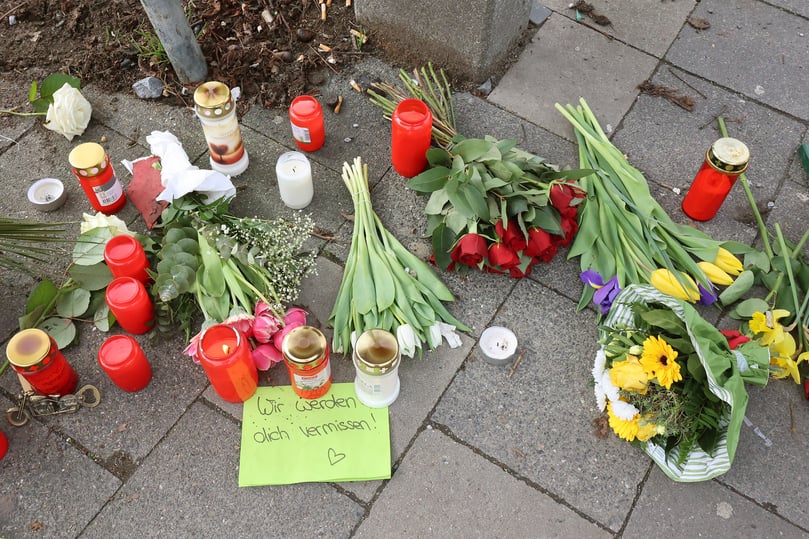 Anteilnahme mit Kerzen und Blumen auf einem Tisch am Rande des Schlossplatzes.