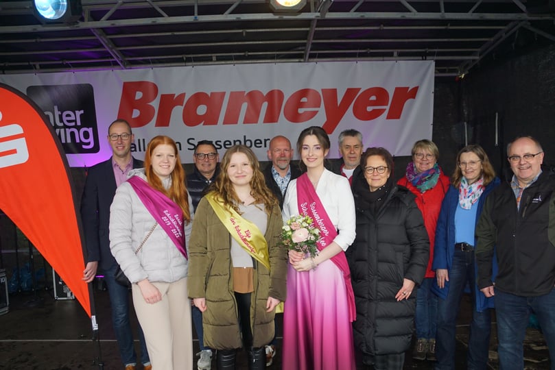 Andreas Wienker (Sparkasse Münsterland Ost), Sarah Kraßort (ausgeschiedene Schachblumenfee), Fabio Zanella, die aktuelle Elfe Denise Schmedt, Sponsor Udo Brameyer, Jakob Klassen, Anja Vogel-Pankewitsch, Sabine Landau, Annette Korte und Hubert Korte (Orga-Team) freuen sich, dass der Schachblumenmarkt endlich wieder stattfinden kann. Besseres Wetter hätten sie sich dennoch gewünscht.
