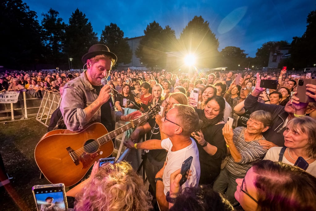 Johannes Oerding zeigt beim Open-Air-Konzert im Ravensberger Park Nähe zu den Fans: Zuschauer Sascha darf „So schön“ singen und bekommt Freibier sowie die Taxifahrt nach Hause spendiert.