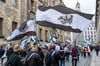 Mehrere hundert Teilnehmer einer Demonstration ziehen mit Flaggen vom Königreich Preußen (schwarz-weiß-schwarz mit Adler) durch die Stadt.