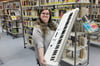 Jeannette Hammel, seit November Leiterin der Espelkamper Stadtbücherei, zeigt, was Interessierte in der Bibliothek der Dinge alles ausleihen können - zum Beispiel ein Keyboard.