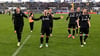 Ein großer Sieg in der Ferne: Joel Grodowski, Sebastian Mrowca und Marc Lorenz (vorne v.l.n.r.) feierten mit Mannschaft und Fans.