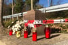 Absperrband der Polizei und Kerzen am Sockel des umgekippten Kreuzes in Büren-Breken.
