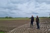 Hubertus Spüntrup (l.) und André Kückmann stehen im Matsch. Die gute Nachricht: Einige Meter weiter unten wächst das Getreide langsam  - trotz des vielen Regens.