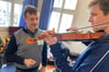 Soitirios Zigopoulos (links) erklärt auch mal einem Vater die Haltung einer Geige.