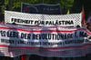 Teilnehmer einer Demonstration in Berlin versammeln sich und halten Banner mit der Aufschrift „Freiheit für Palästina“.