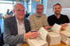 Dr. Heinz-Ulrich Kammeier (von links), Dr. Peter Krevert und Christian Bach signieren die ersten Exemplare in Steinfurt.