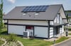 Ein Haus mit einer Solaranlage auf dem Dach und einer Wärmepumpe: So soll der Beitrag der Immobilieneigentümer aussehen, um das Ziel der Klimaneutralität zu erreichen.