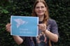 Was bedeutet Frieden für Sie? Redaktionsvolontärin Jule Müller präsentiert das Plakat zur Video-Aktion.