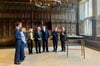 Am Ort historischer Strahlkraft ließ der französische Präsident seinen Blick schweifen: Friedenspreisträger Emmanuel Macron (2.v.re.) wurde von Oberbürgermeister Markus Lewe (rechts) im Friedenssaal begrüßt.