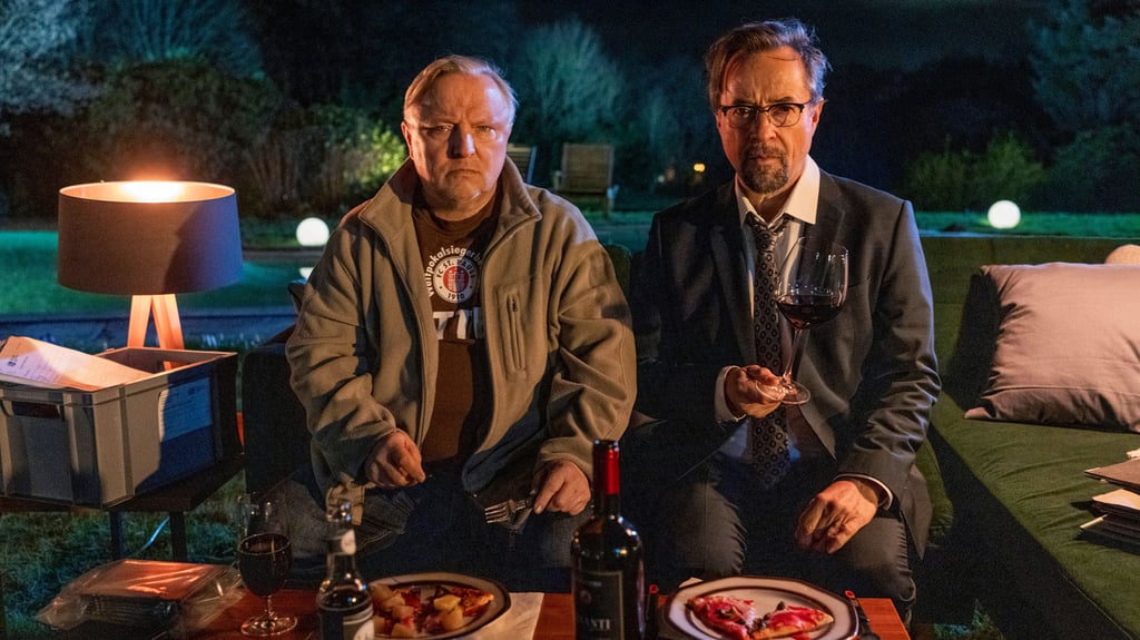 Der neue "Tatort" aus Münster: Bei TK-Pizza und Rotwein sinnieren Hauptkommissar Thiel (Axel Prahl, l.) und Dr. Karl-Friedrich Boerne (Jan Josef Liefers, r.) über die möglichen Szenarien des tödlichen Unfalls nach dem Streit zwischen Doreen Prätorius (Cordelia Wege) und Oskar Weintraub (Nils Bunkhorst).