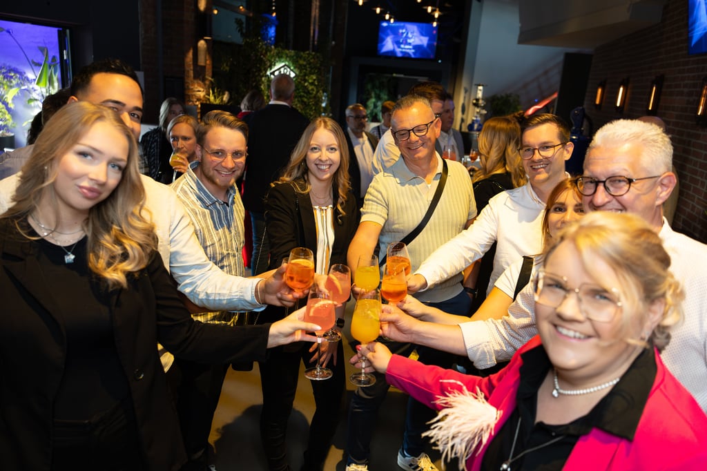 Mitarbeiter des Schloß Holte-Stukenbrocker Unternehmens ARI-Armaturen stoßen bei der Jubiläumsfeier auf die Zukunft an.