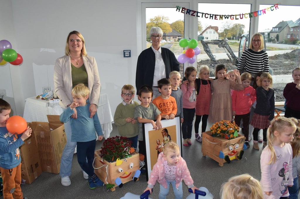 Maike Brinkhues (stv. Kita-Leiterin), Mechthild Oskamp (Kita-Leiterin) und Alex Gotthard (Erzieherin) freuen sich mit den Kindern über ihr schönes neues Domizil.